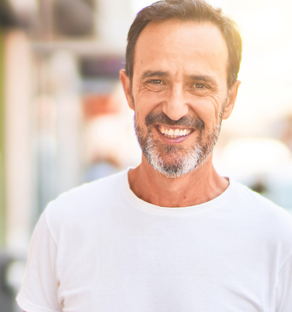 Middle age handsome man standing on the street smiling