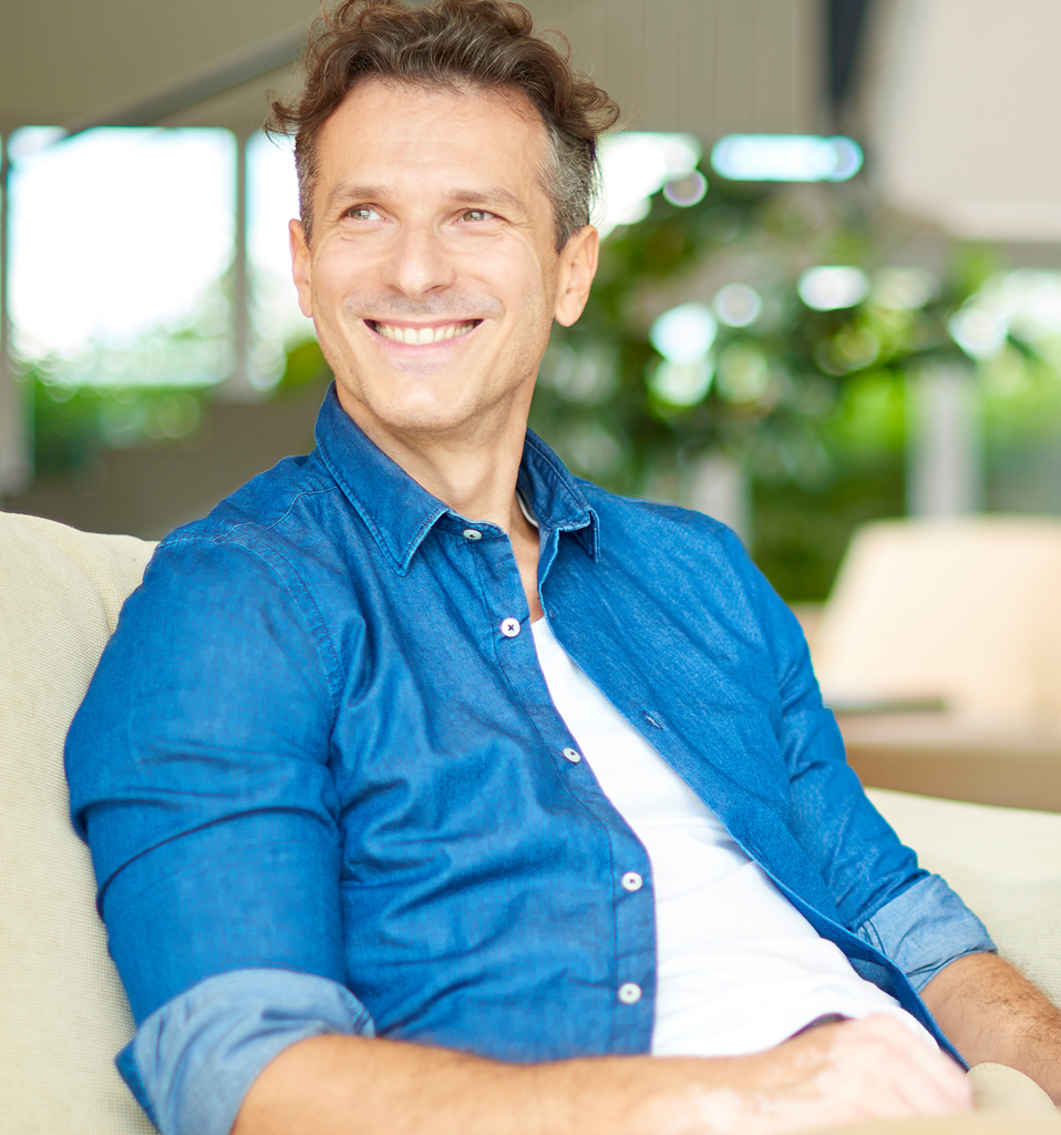Casual handsome man relaxing at home. Shot a smiling middle aged man relaxing at home on the couch.