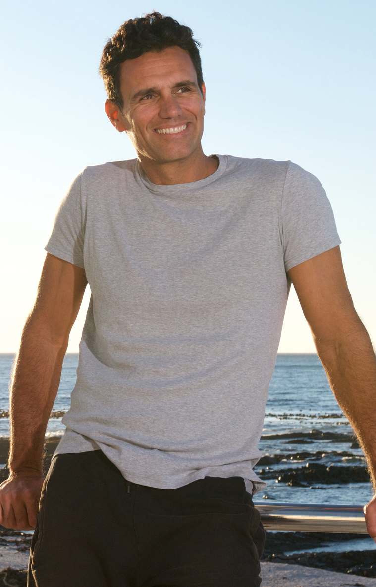 handsome middle age man smiling by sea